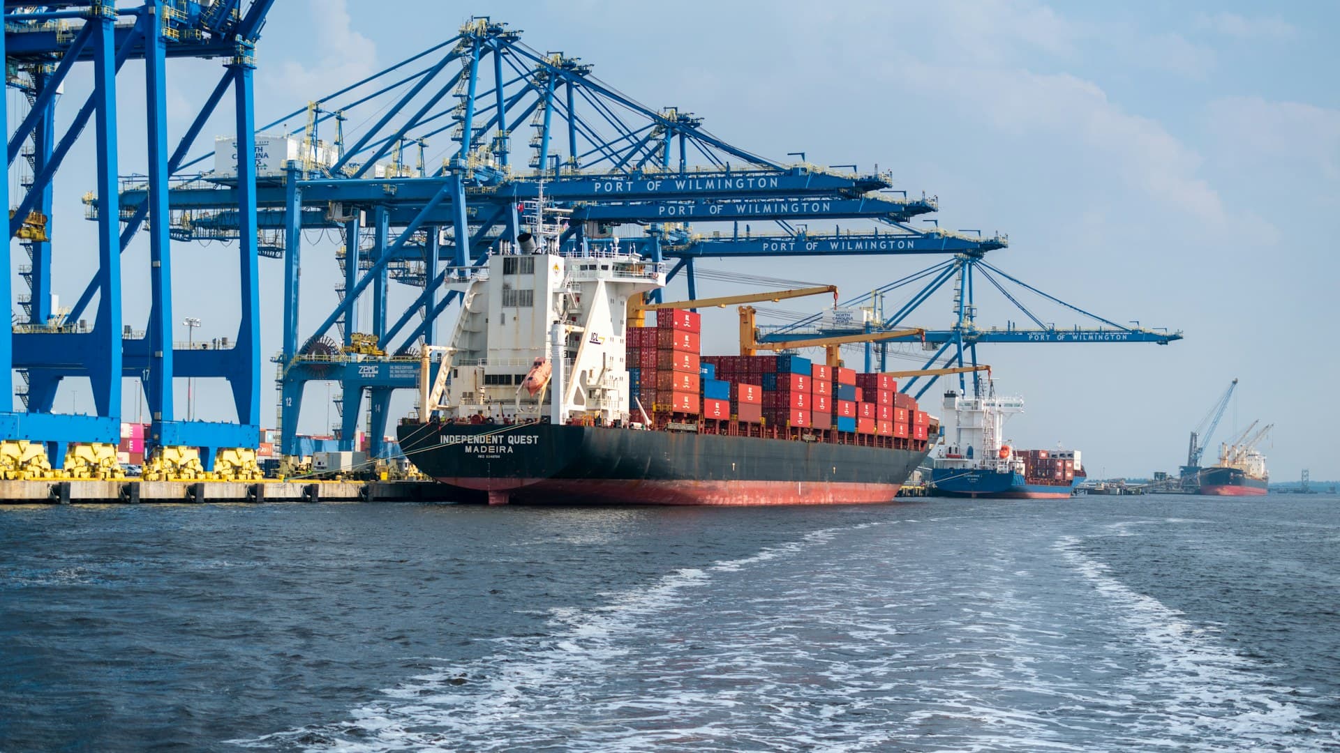 Container ship docked at Port of Wilmington under blue gantry cranes